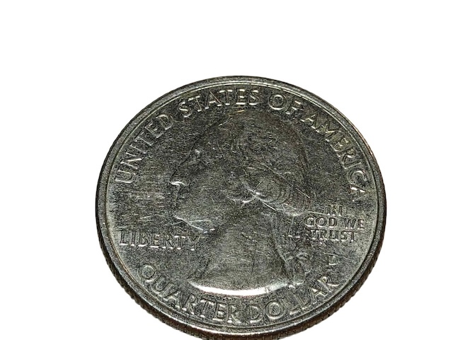 2012 quarter die chip error showing raised metal lump in letter or design element caused by a chip in the working die